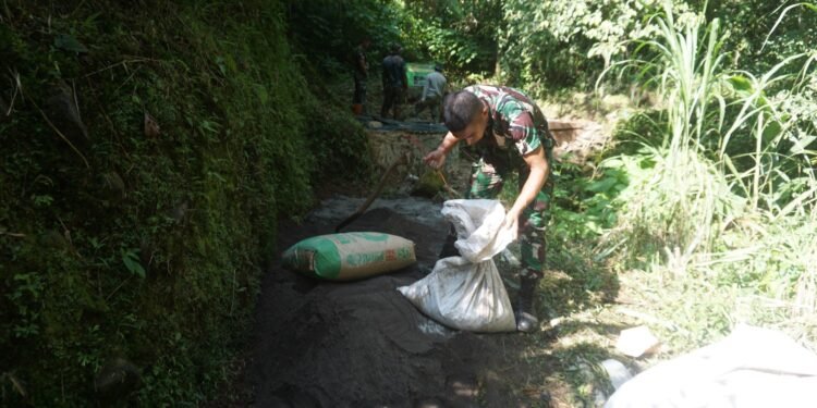 Melalui Jalan Yang Menanjak Anggota Satgas TMMD Reguler Ke 121 Angkut Bahan Material Dengan di Pikul Bersama