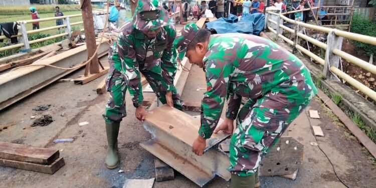 Babinsa Koramil 06/Tersono Bantu Perbaiki Jembatan Kalibelo Yang Rusak Akibat Banjir Bandang