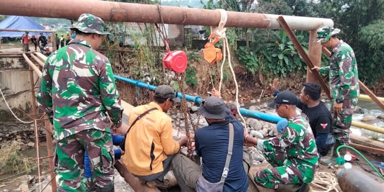 Babinsa Koramil 06/Tersono Bantu Perbaiki Jembatan Kalibelo Yang Rusak Akibat Banjir Bandang