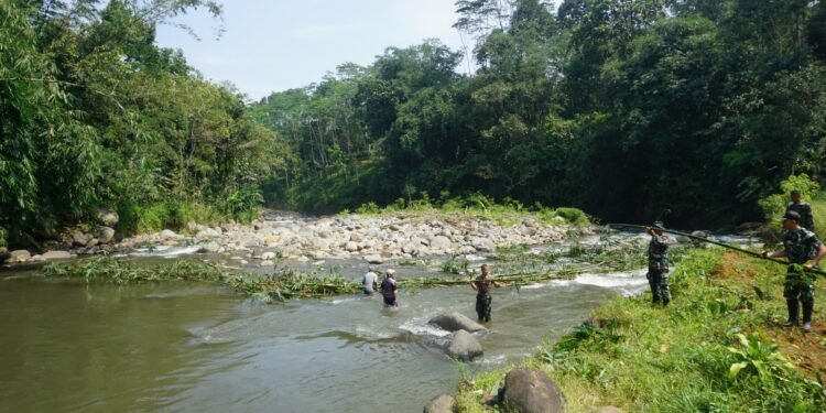 Gotong Royong Penuh Semangat, TNI dan Warga Bersihkan Lokasi Pembangunan Jembatan Gantung
