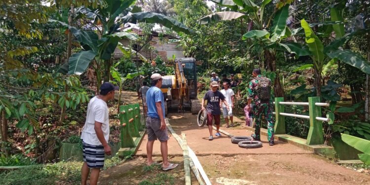 Babinsa Kawal Distribusi Alat Berat ke Lokasi Pembangunan Jembatan Garuda