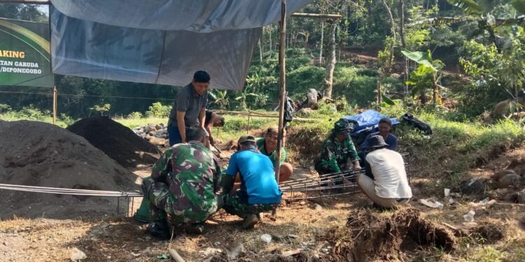 Warga bersama TNI melakukan perakitan besi untuk pondasi cakar ayam sebagai bagian dari pembangunan infrastruktur jembatan