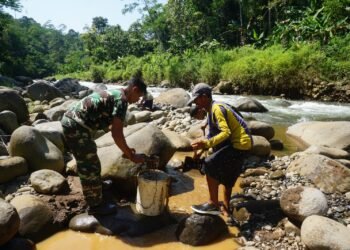Babinsa 07/Bandar Bersama Warga Pecahkan Batu Sungai Matrial cor tanggul Jembatan Garuda