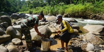 Babinsa 07/Bandar Bersama Warga Pecahkan Batu Sungai Matrial cor tanggul Jembatan Garuda